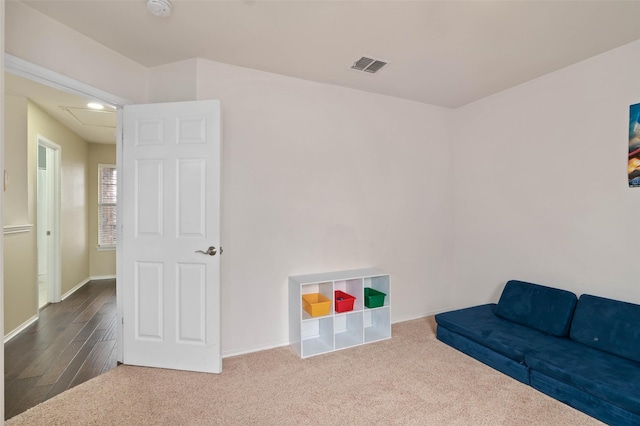 sitting room with carpet flooring, visible vents, and baseboards