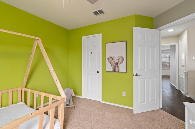 bedroom featuring carpet floors, visible vents, and baseboards