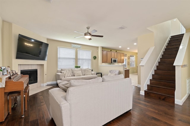 living room featuring dark wood-style floors, a healthy amount of sunlight, visible vents, and stairway