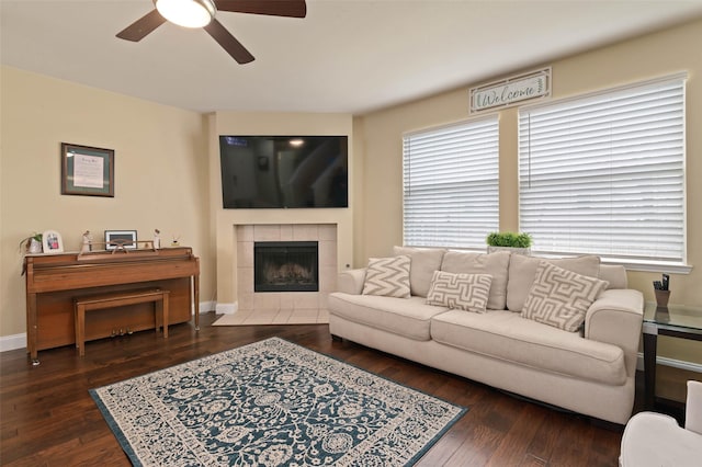 living area featuring a healthy amount of sunlight, baseboards, and dark wood finished floors