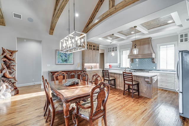 dining area featuring vaulted ceiling with beams, light wood-style flooring, visible vents, and a healthy amount of sunlight