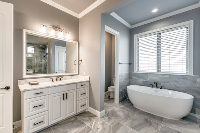 full bath with ornamental molding, a freestanding bath, vanity, and toilet