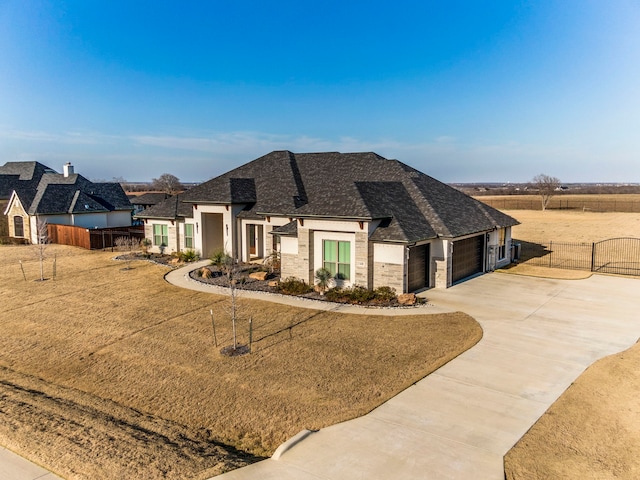 view of front of house featuring concrete driveway, an attached garage, a front yard, fence, and stone siding