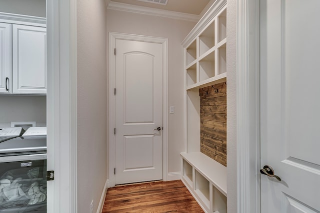 mudroom featuring dark wood-type flooring, crown molding, baseboards, and separate washer and dryer