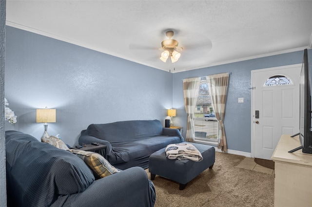 carpeted living area featuring a ceiling fan, baseboards, and crown molding