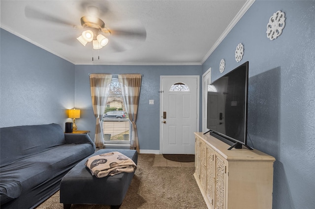 living room featuring a textured wall, light carpet, a ceiling fan, baseboards, and crown molding