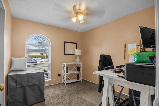 office space featuring a textured ceiling, light carpet, and a ceiling fan