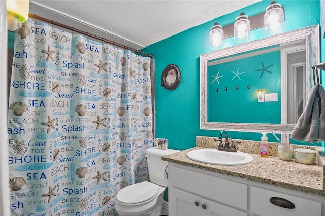 bathroom with curtained shower, vanity, and toilet