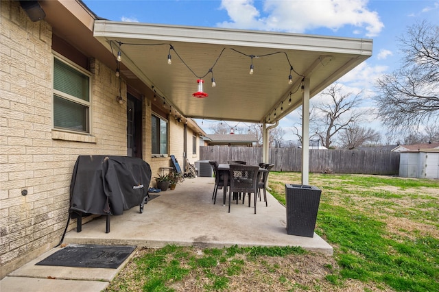 view of patio / terrace with area for grilling, a storage shed, central AC, a fenced backyard, and an outdoor structure