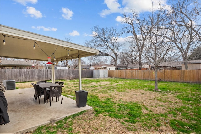 view of yard with a patio area, a fenced backyard, a storage unit, and cooling unit