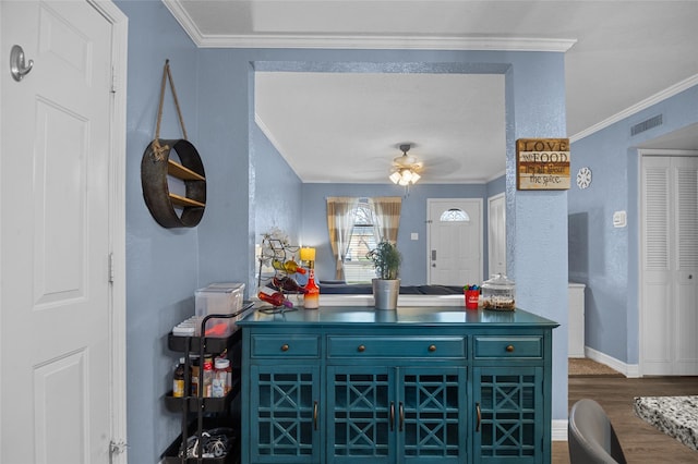 bar featuring baseboards, visible vents, ceiling fan, dark wood-type flooring, and crown molding