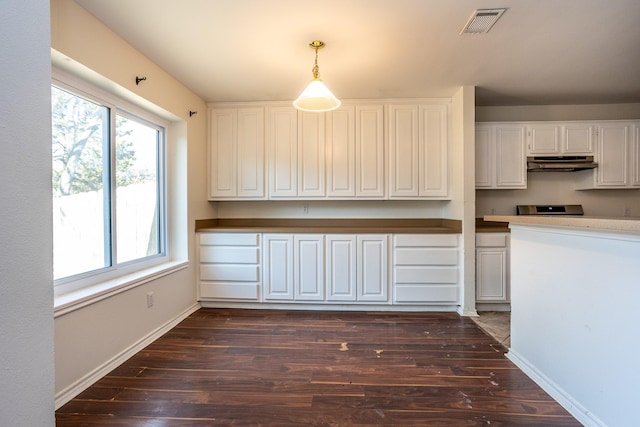 kitchen with under cabinet range hood, dark wood-type flooring, visible vents, white cabinetry, and pendant lighting