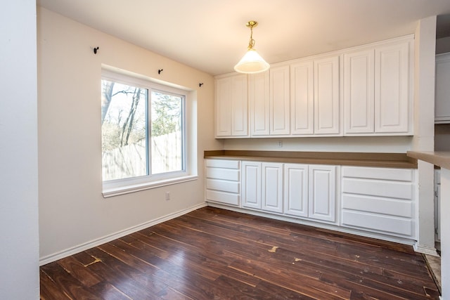 interior space featuring dark wood-type flooring and baseboards