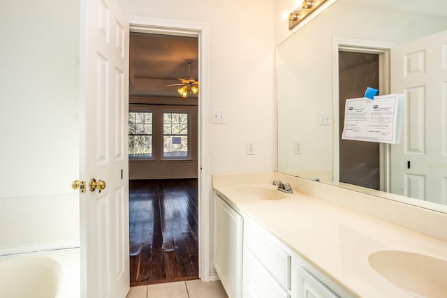 bathroom with double vanity, a tub to relax in, tile patterned flooring, and a sink