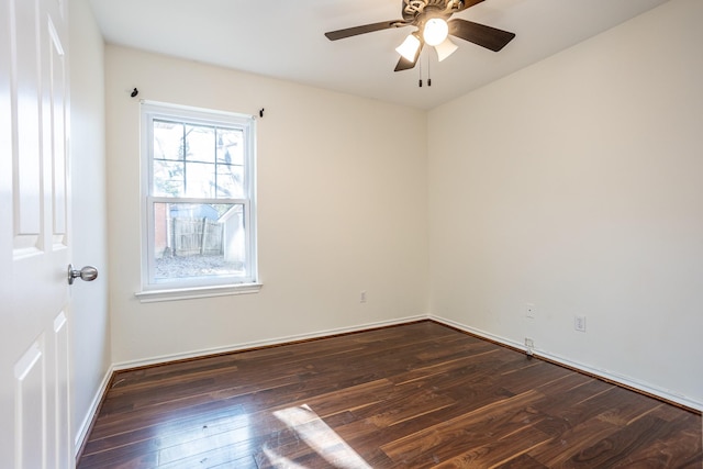 spare room featuring dark wood-style floors, ceiling fan, and baseboards