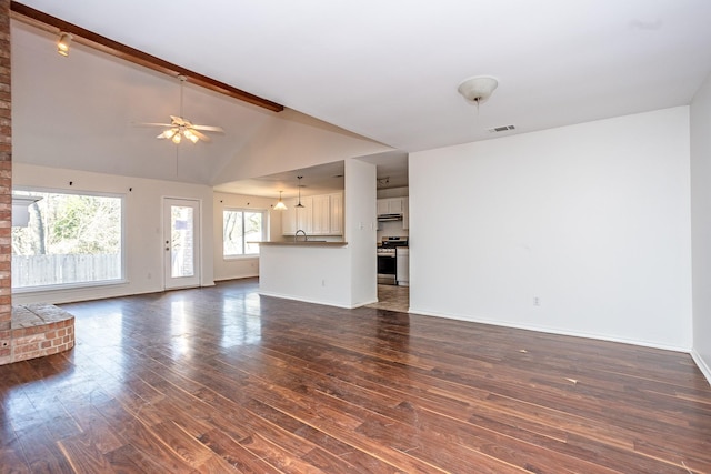 unfurnished living room featuring visible vents, dark wood finished floors, baseboards, ceiling fan, and vaulted ceiling with beams