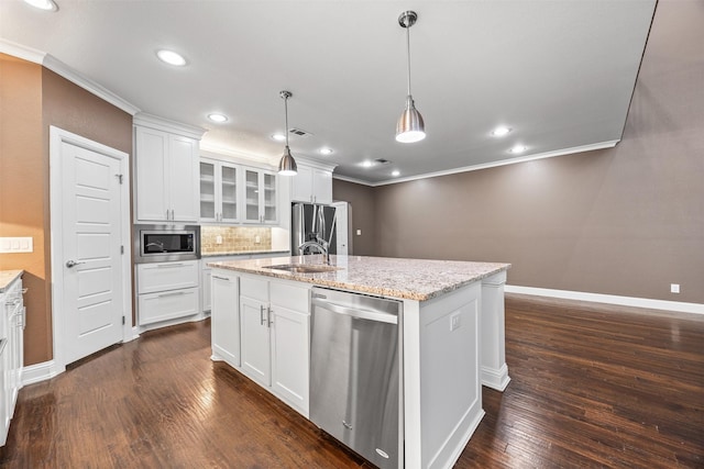 kitchen with appliances with stainless steel finishes, white cabinets, glass insert cabinets, and a center island with sink