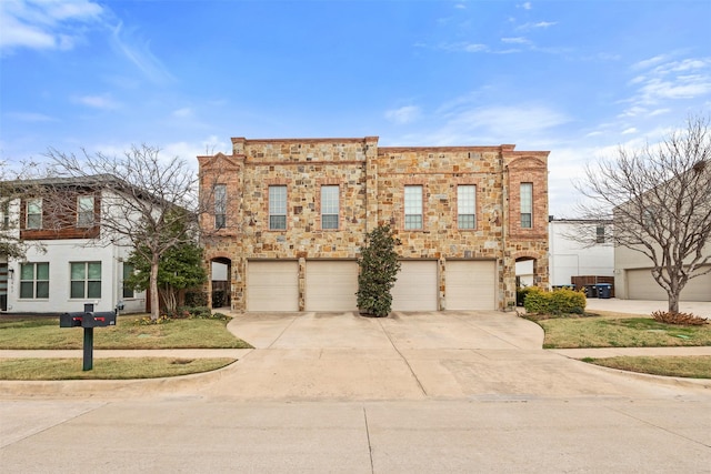 view of front of property featuring a garage, concrete driveway, and stone siding