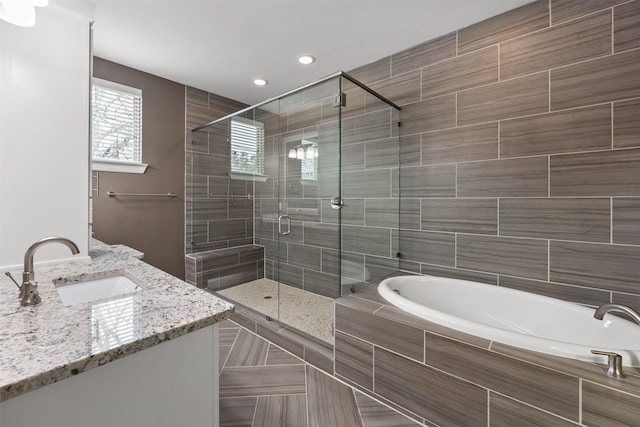 bathroom with a garden tub, a stall shower, and vanity