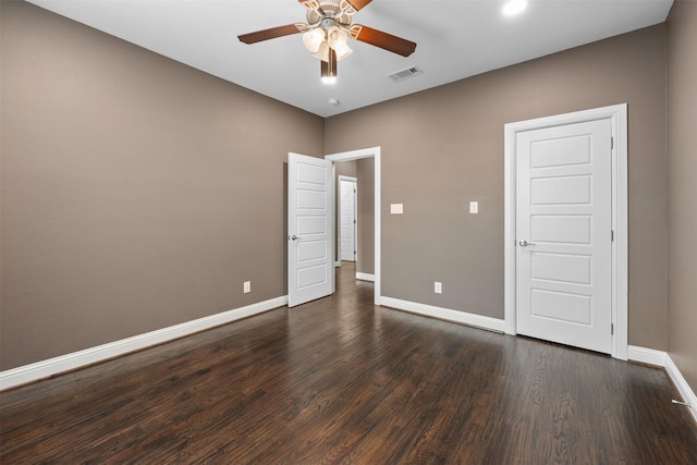 unfurnished bedroom with ceiling fan, dark wood-style flooring, visible vents, and baseboards