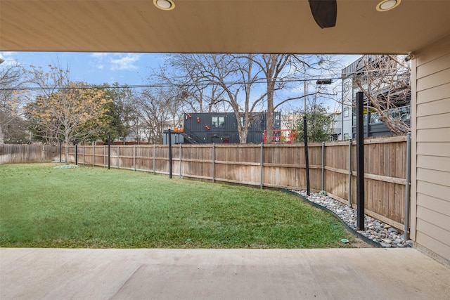 view of yard with a fenced backyard and a ceiling fan