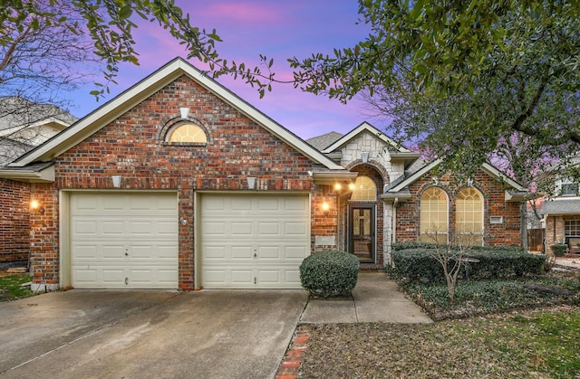 view of front of property featuring stone siding, concrete driveway, brick siding, and an attached garage