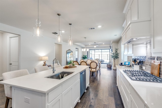 kitchen featuring a breakfast bar, a sink, dark wood-style floors, decorative backsplash, and dishwasher