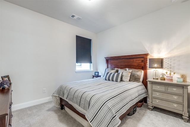 bedroom with visible vents, light carpet, and baseboards