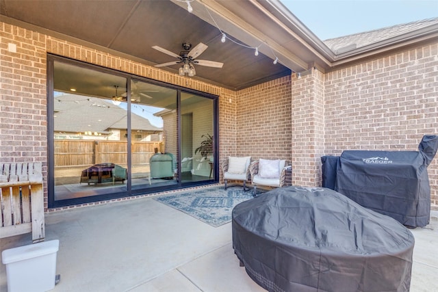 view of patio with ceiling fan, grilling area, and fence