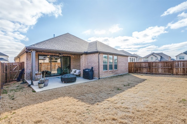 back of property with a shingled roof, a lawn, a fenced backyard, a patio area, and brick siding