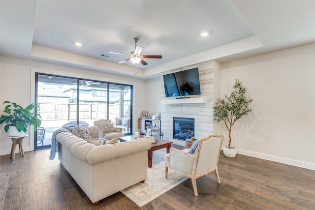 living area featuring dark wood-type flooring and a raised ceiling