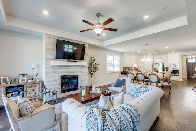 living area featuring recessed lighting, dark wood-type flooring, a fireplace, a ceiling fan, and baseboards