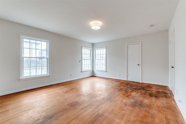 empty room with hardwood / wood-style flooring and baseboards
