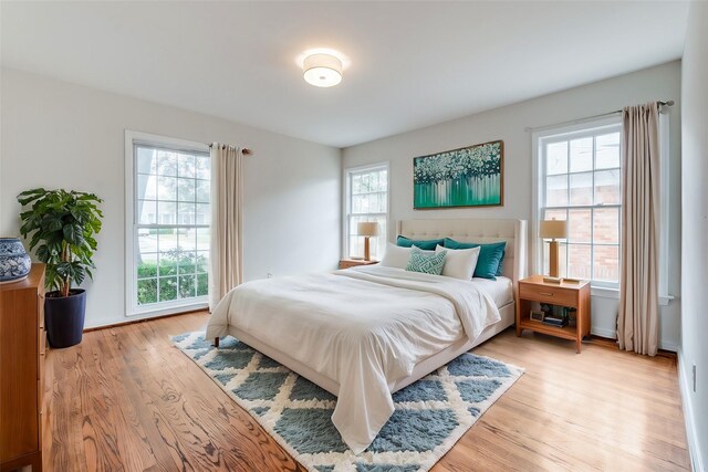bedroom featuring multiple windows and light wood-style floors