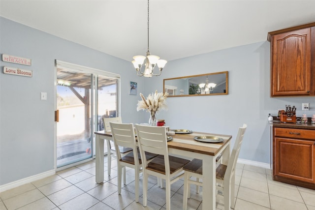 dining room with a chandelier, light tile patterned flooring, and baseboards