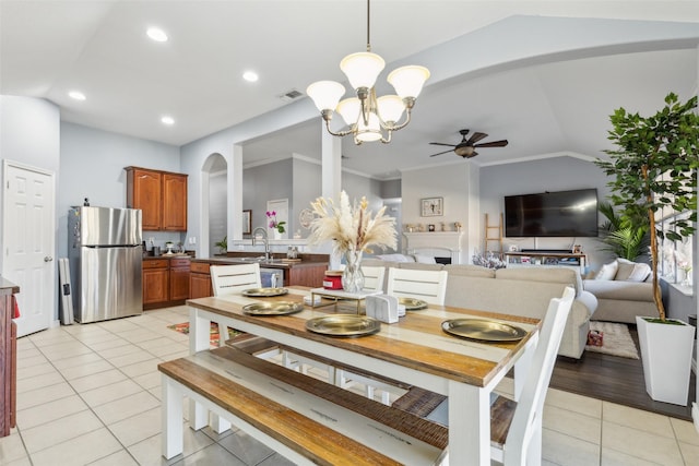 dining area with a ceiling fan, lofted ceiling, visible vents, and light tile patterned floors