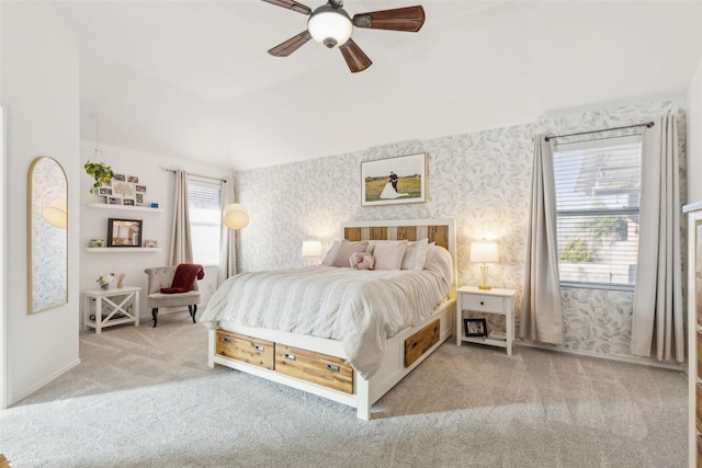 carpeted bedroom featuring wallpapered walls, vaulted ceiling, and a ceiling fan