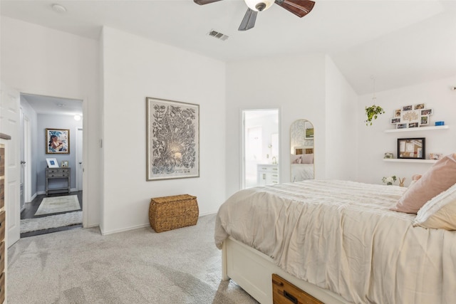 bedroom featuring ceiling fan, lofted ceiling, connected bathroom, light colored carpet, and visible vents