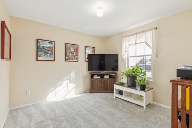 carpeted living area featuring baseboards