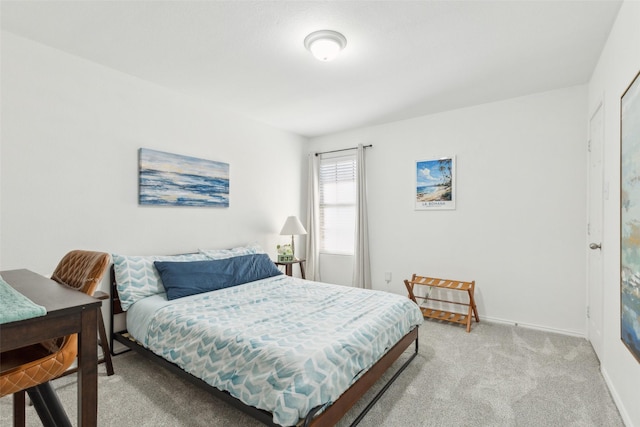 bedroom featuring light carpet and baseboards