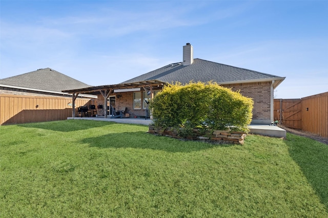 back of property with a yard, a fenced backyard, a patio, and brick siding