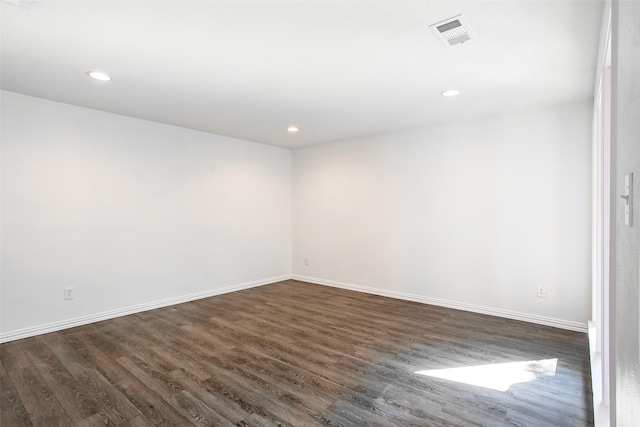 spare room with recessed lighting, dark wood-style flooring, visible vents, and baseboards