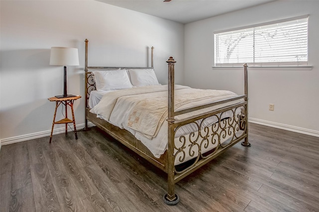 bedroom with dark wood-type flooring and baseboards