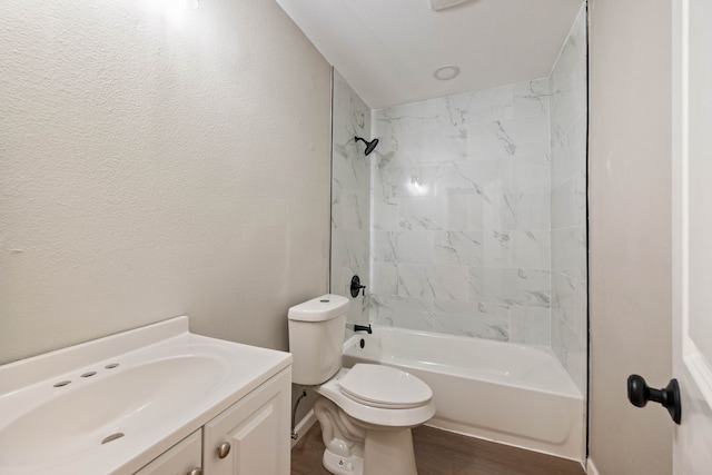 3721 Stuart Dr, Fort Worth, TX 76110 - full bathroom with a textured wall, toilet, wood finished floors, vanity, and shower / bathing tub combination
