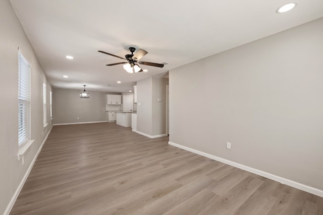 unfurnished living room with light wood finished floors, recessed lighting, a ceiling fan, and baseboards