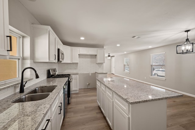 3721 Stuart Dr, Fort Worth, TX 76110 - kitchen featuring backsplash, stainless steel appliances, a sink, and wood finished floors