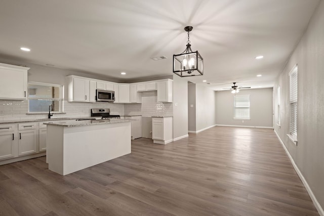 3721 Stuart Dr, Fort Worth, TX 76110 - kitchen with white cabinets, visible vents, stainless steel appliances, and wood finished floors