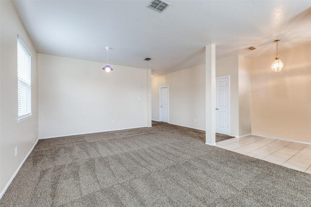 unfurnished room with light colored carpet, visible vents, baseboards, and light tile patterned floors