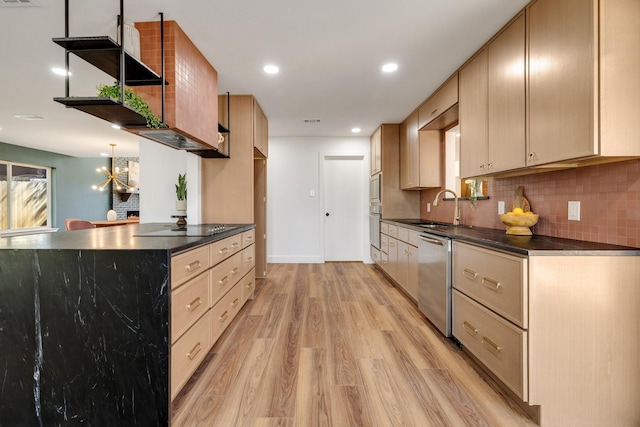 4707 Weyhill Dr, Arlington, TX 76013 - kitchen with stainless steel appliances, dark countertops, light wood-type flooring, decorative backsplash, and a sink