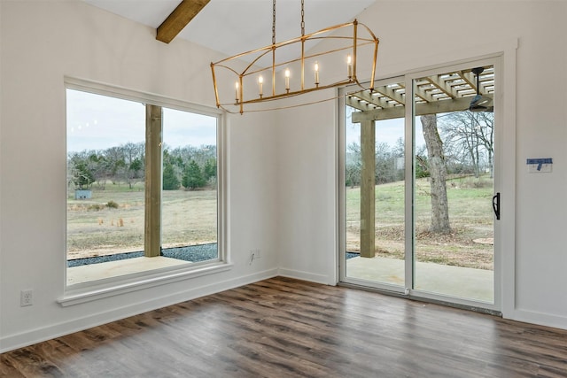 unfurnished dining area featuring beam ceiling, dark wood finished floors, and baseboards